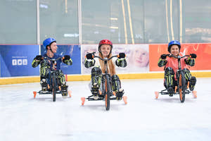 Barn, der kører på trehjulet cykel i Dubai Ice Rink