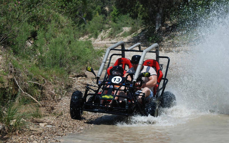 Mann fährt mit einem Buggy durch den Fluss
