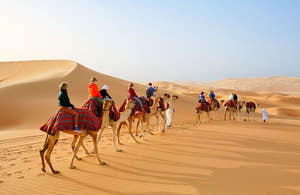 People camel trekking through the desert