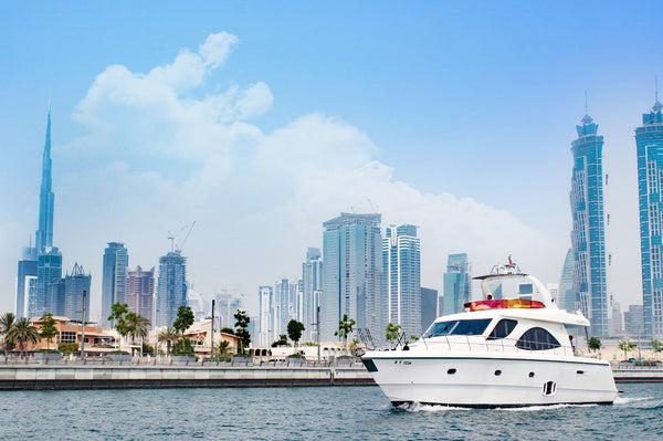 yacht cruising on the water with the Dubai skyline