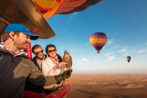 Folk med en falk i en varmluftballon