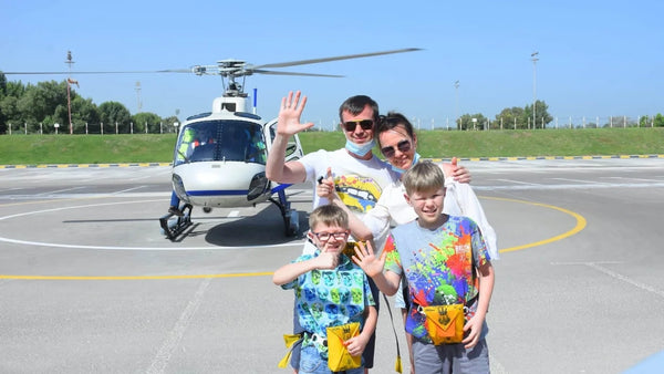 Family taking photo in front of a helicopter