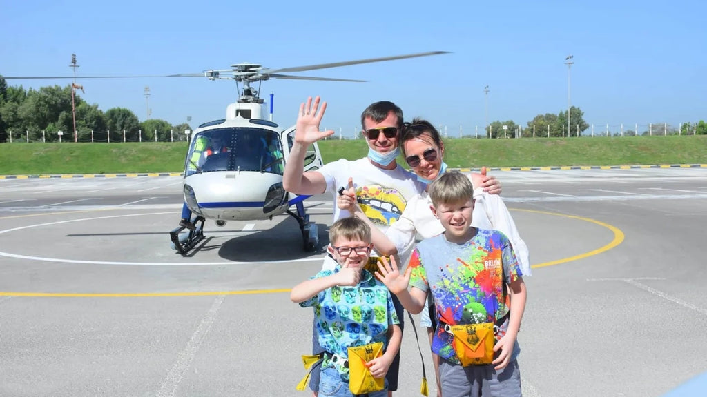 Family taking photo in front of a helicopter