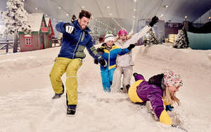 Familie leger i sneen i Abu Dhabi Snow Park