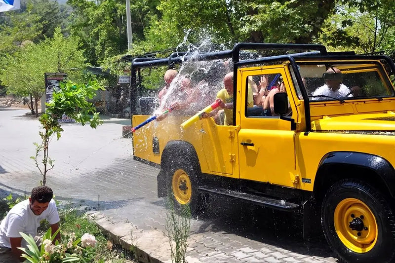 People spraying water from a jeep