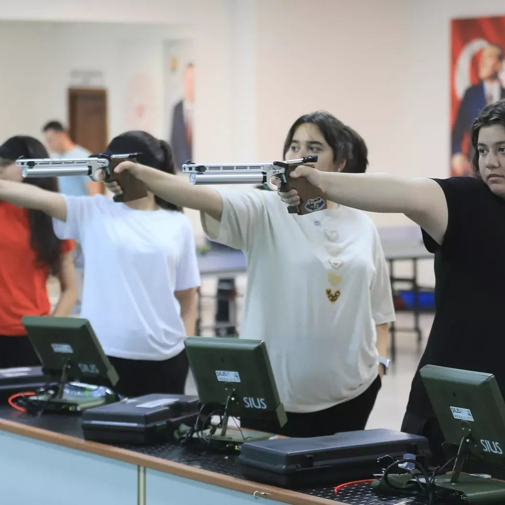 girls practicing to shoot guns