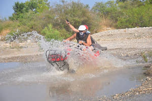 Folk kører ATV/quad i en flod