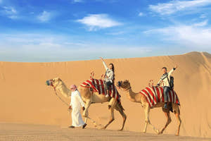 Par, der nyder en kameltur i Dubais ørken