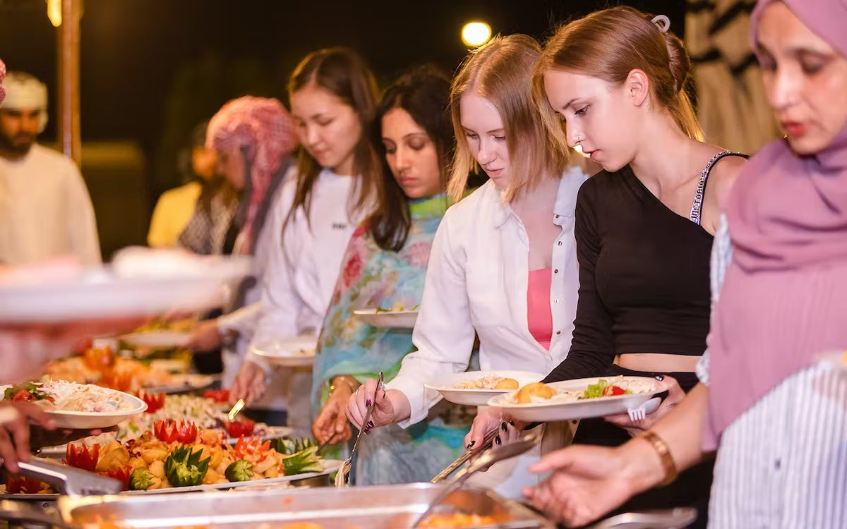 A sumptuous BBQ dinner spread set up under the starry desert sky.