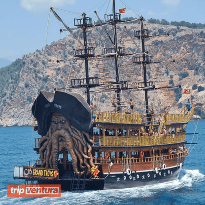 Happy family posing on the deck of the pirate boat with the Alanya coast in the background