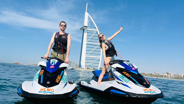 Couple are enjoying a jet ski tour with the iconic Burj Al Arab hotel