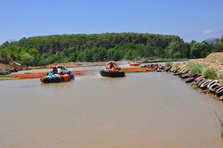 People driving hovercraft in the water