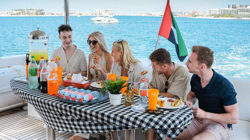 Gäste beim BBQ-Mittagessen auf einer luxuriösen Gemeinschaftsyacht