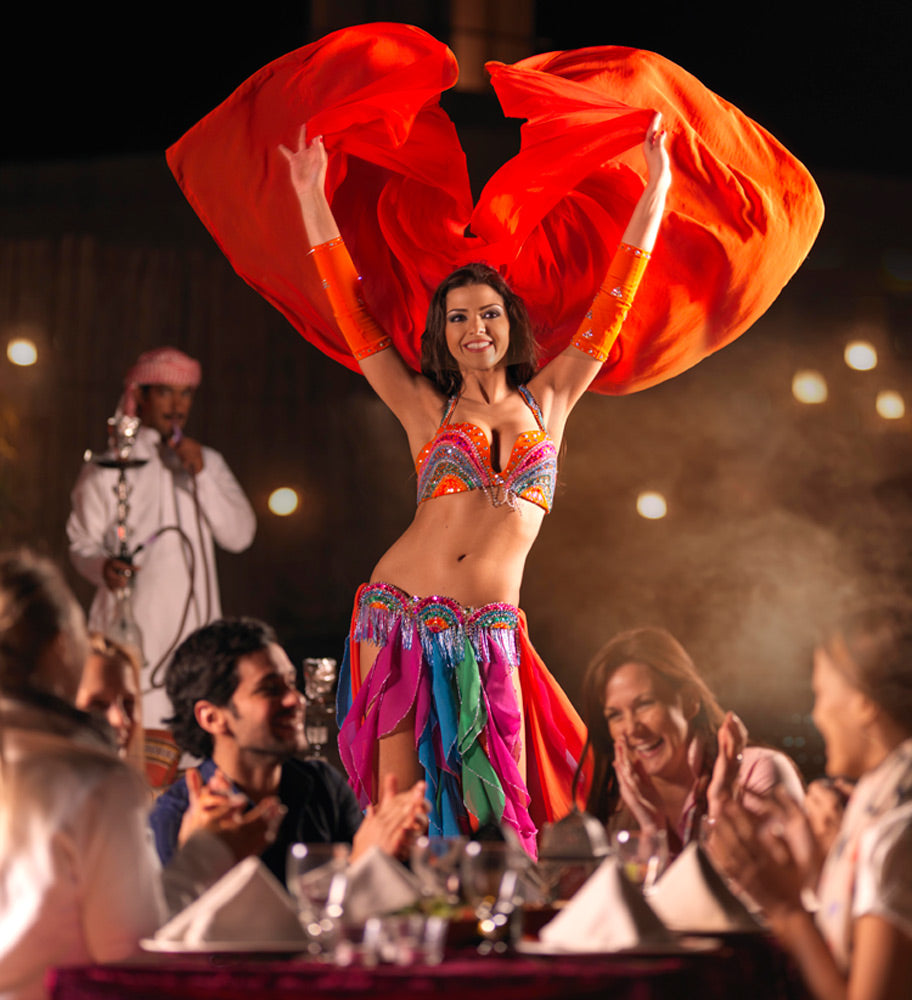 Professional belly dancer performing under vibrant lights at the desert camp.