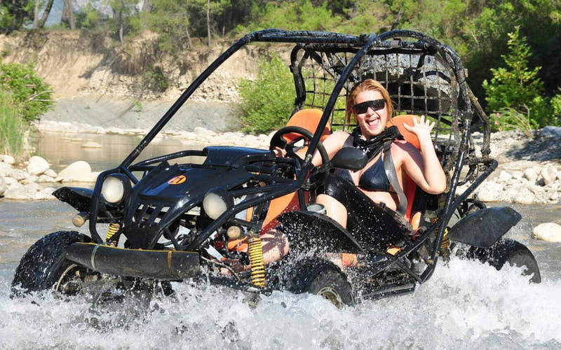 Frau fährt mit einem Buggy durch den Fluss