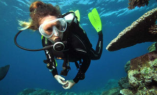 A girl scuba diving and exploring coral reefs