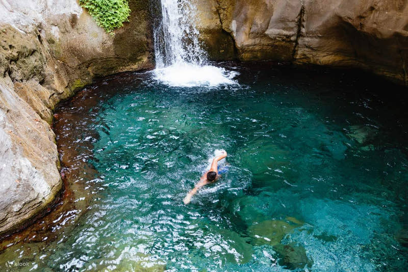 Mann schwimmt am Wasserfall im Sapadere Canyon