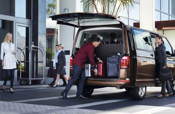 Мужчина выгружает багаж из фургона