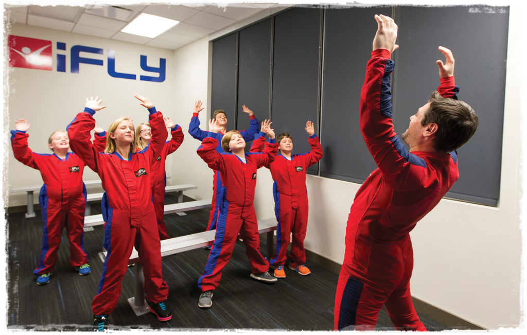 people participating in indoor skydiving at an iFLY facility