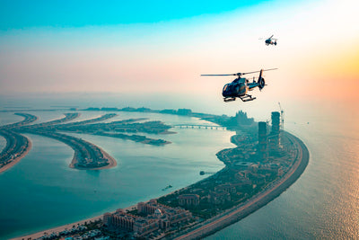 Helicopter flying in Dubai, specifically showcasing the iconic Palm Jumeirah islands. 