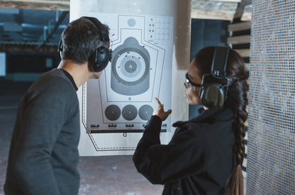 Couple analysing target after shooting practice