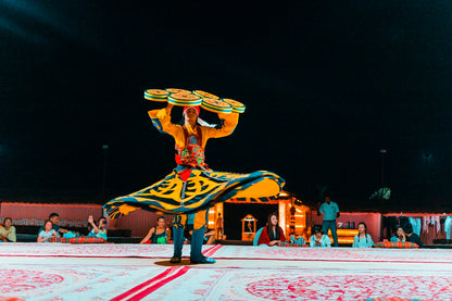 Tanoura dancer performing under colorful lights at the premium camp.