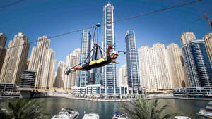 Mand nyder zipline over marinaen